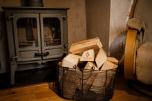 Load image into Gallery viewer, Basket of firewood logs in front of a fireplace.